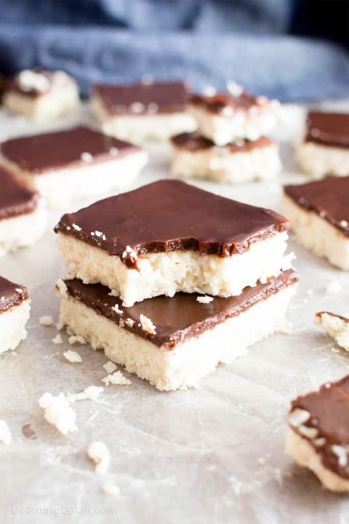Bunch of square slices of 5-Ingredient Vegan Coconut Chocolate Bars on a parchment paper