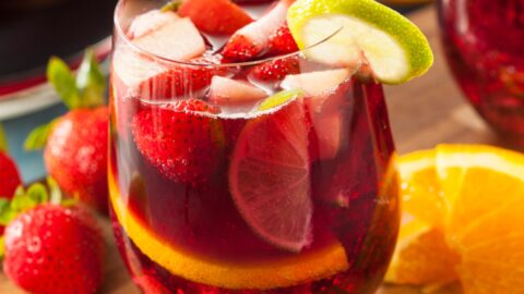 A Glass of Cold Red Sangria with Strawberries, Orange and Lime