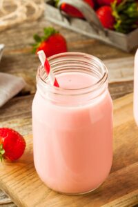 A Jar of Strawberry Milk on a Wooden Table
