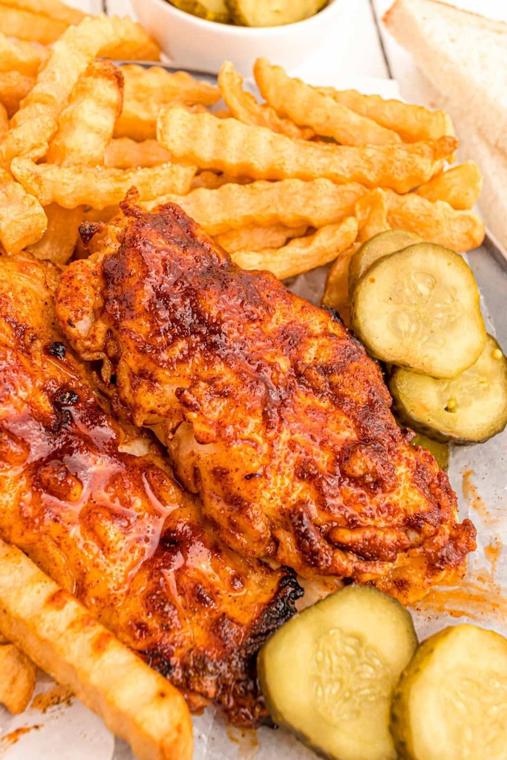 Air Fryer Nashville Hot Chicken with fries and slice cucumber on the side