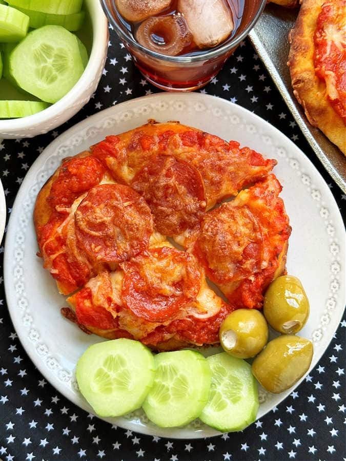 Homemade Air Fryer Pepperoni Cheese Pizza on a plate with slice cucumber and olives on the side
