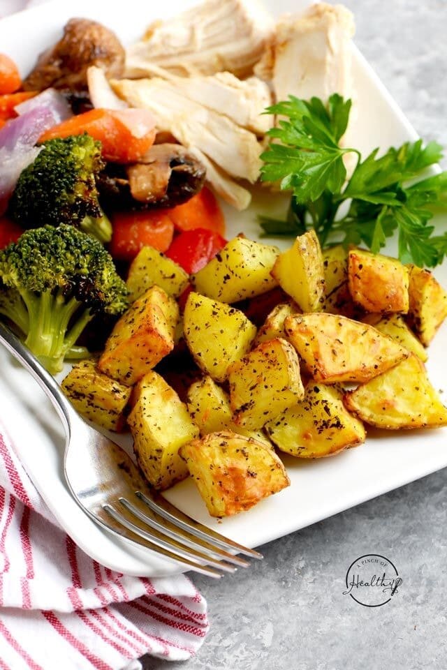 Air Fryer Roasted Potatoes served on a plate with broccoli, bell peppers and chicken breast