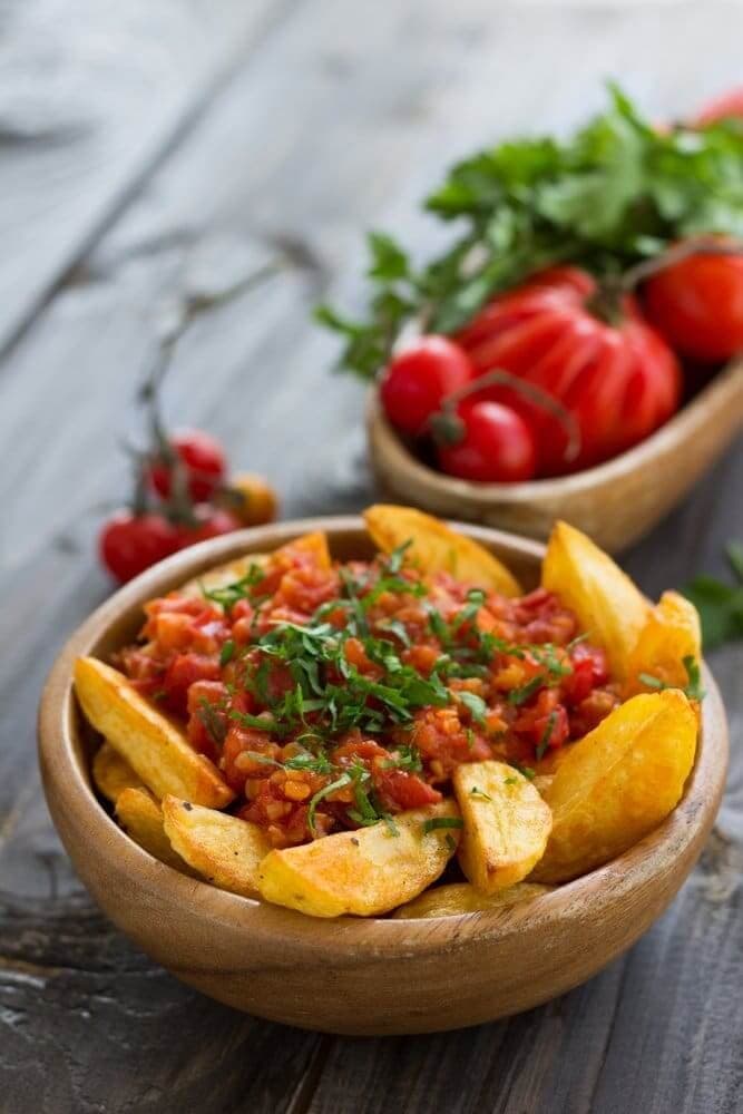 Homemade Air Fryer Spanish Spicy Potatoes (Patatas Bravas) on a wooden bowl