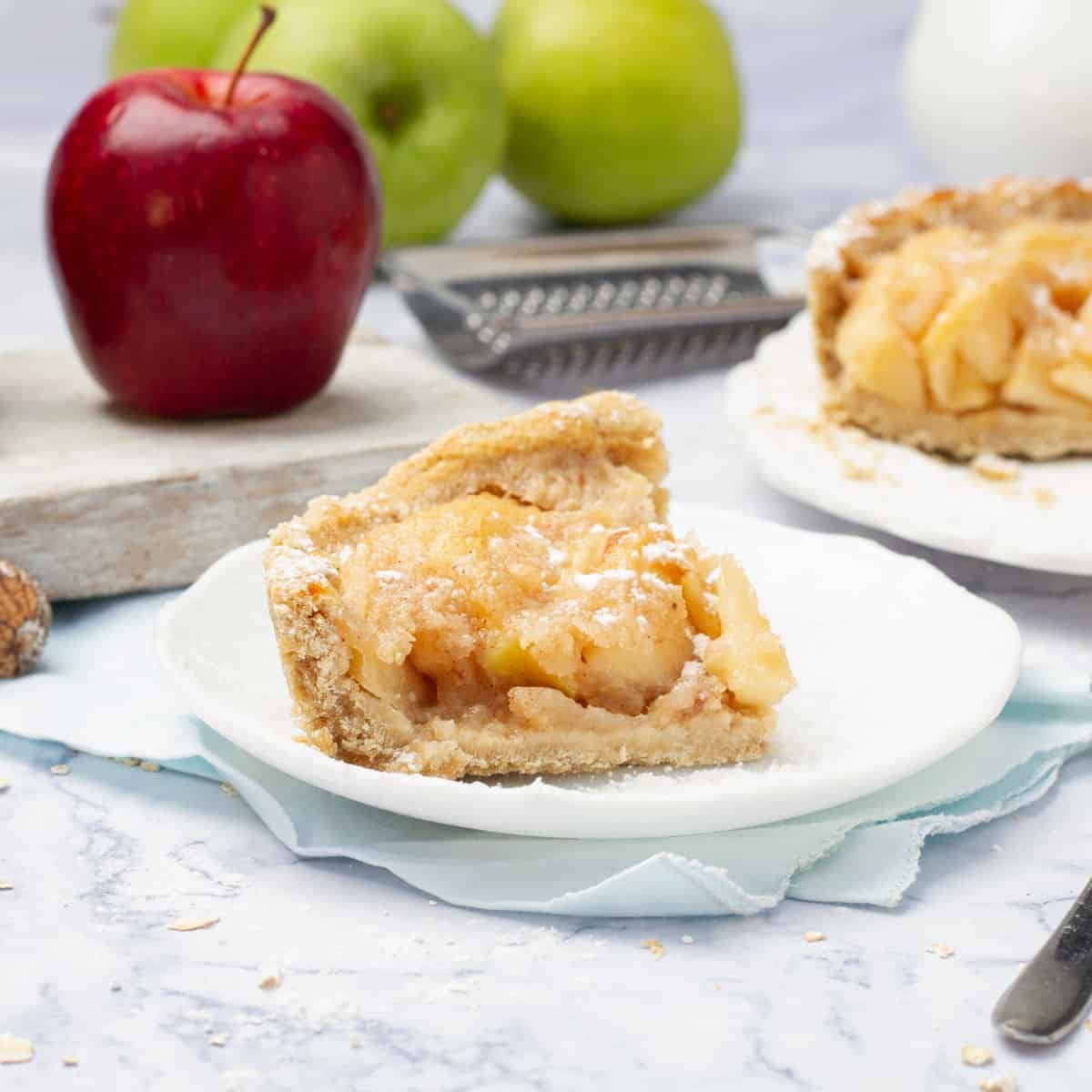 A slice of apple pie on a plate with a fork