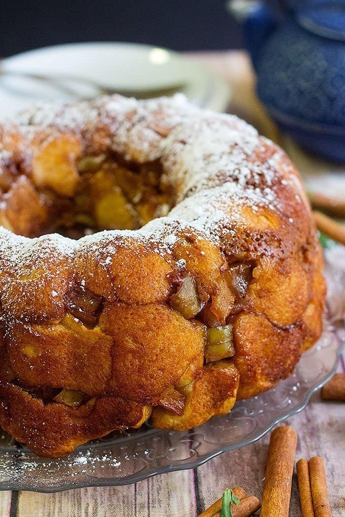 Apple pie monkey bread coated with cinnamon and brown sugar on a cake try. 
