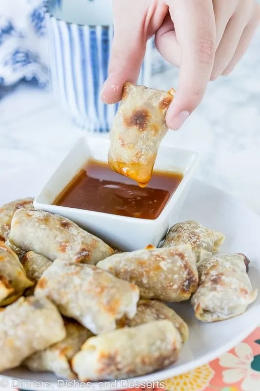 Hand dipping baked turkey stuffed wonton in dipping sauce. 