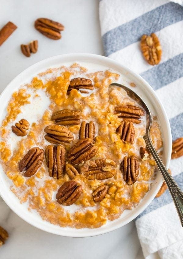 Bowl of pumpkin oatmeal with pecan nuts.