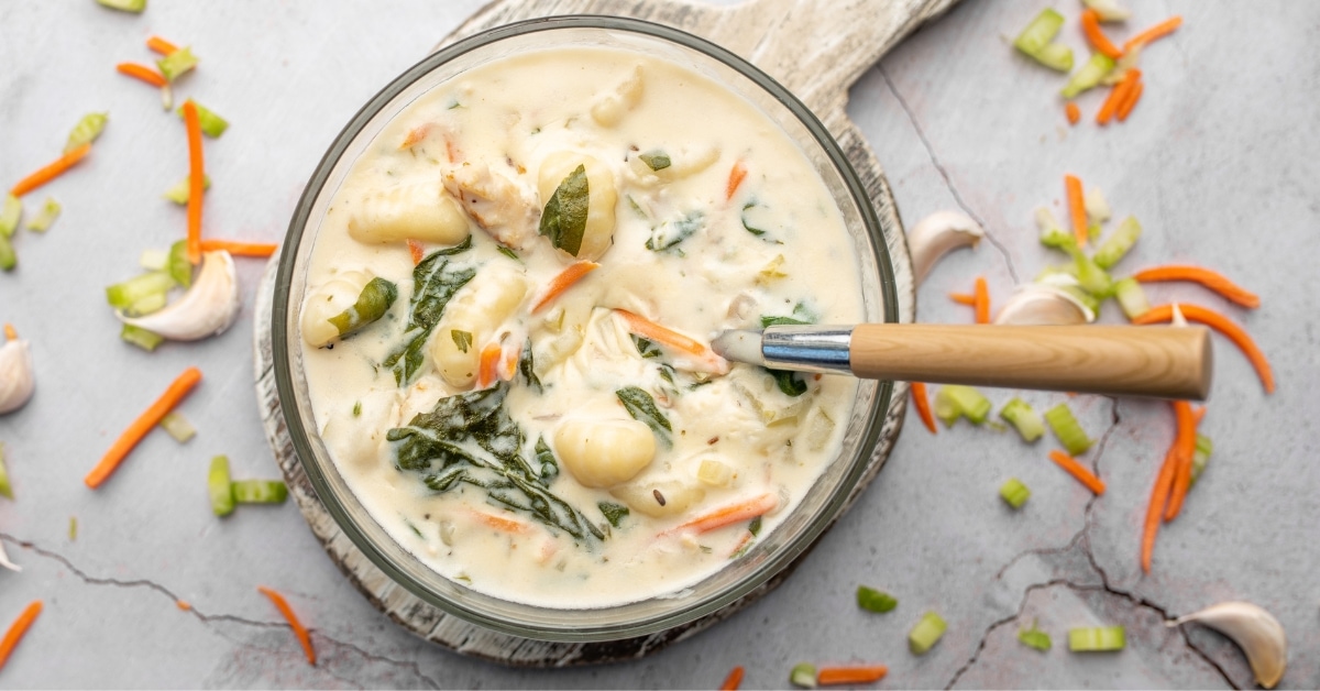 Bowl of Creamy Chicken and Gnocchi Soup with Colorful Veggies
