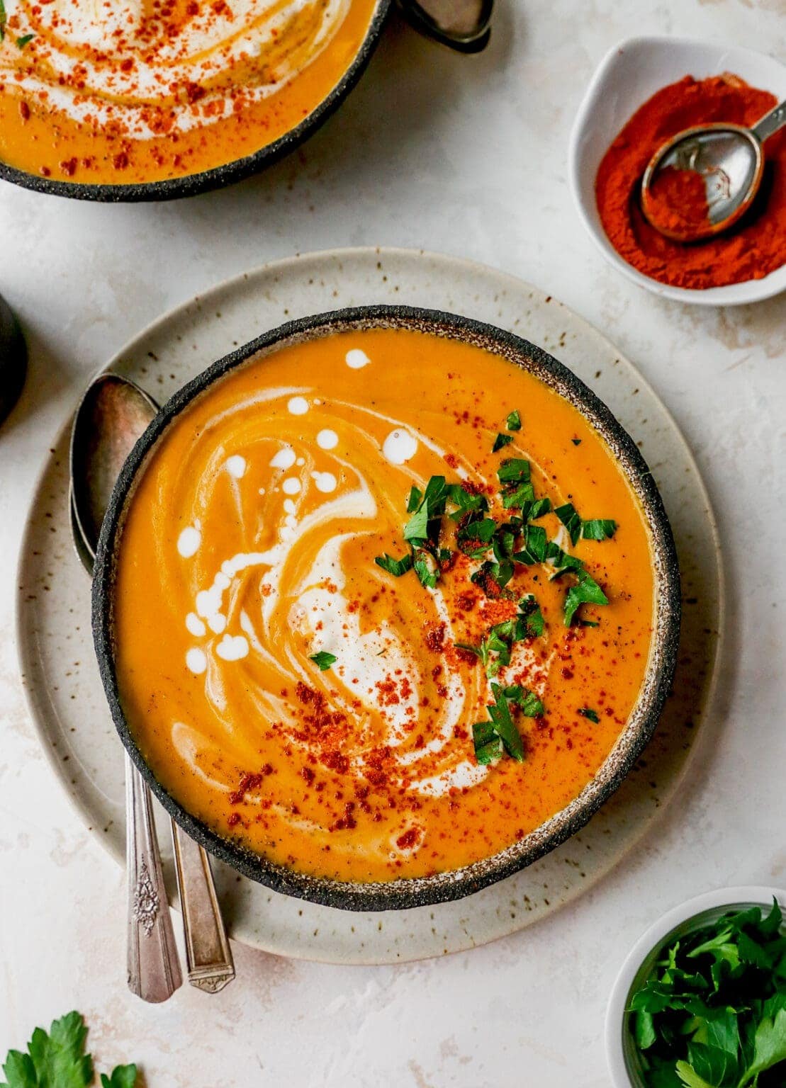 Bowls of homemade Sweet Potato Soup garnished with paprika powder and cilantro