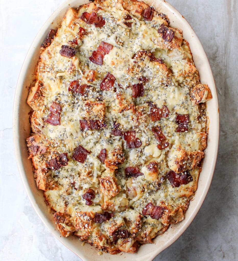 Breakfast sandwich strata made with bagels, crispy bacon, and cheese in a custardy casserole. 