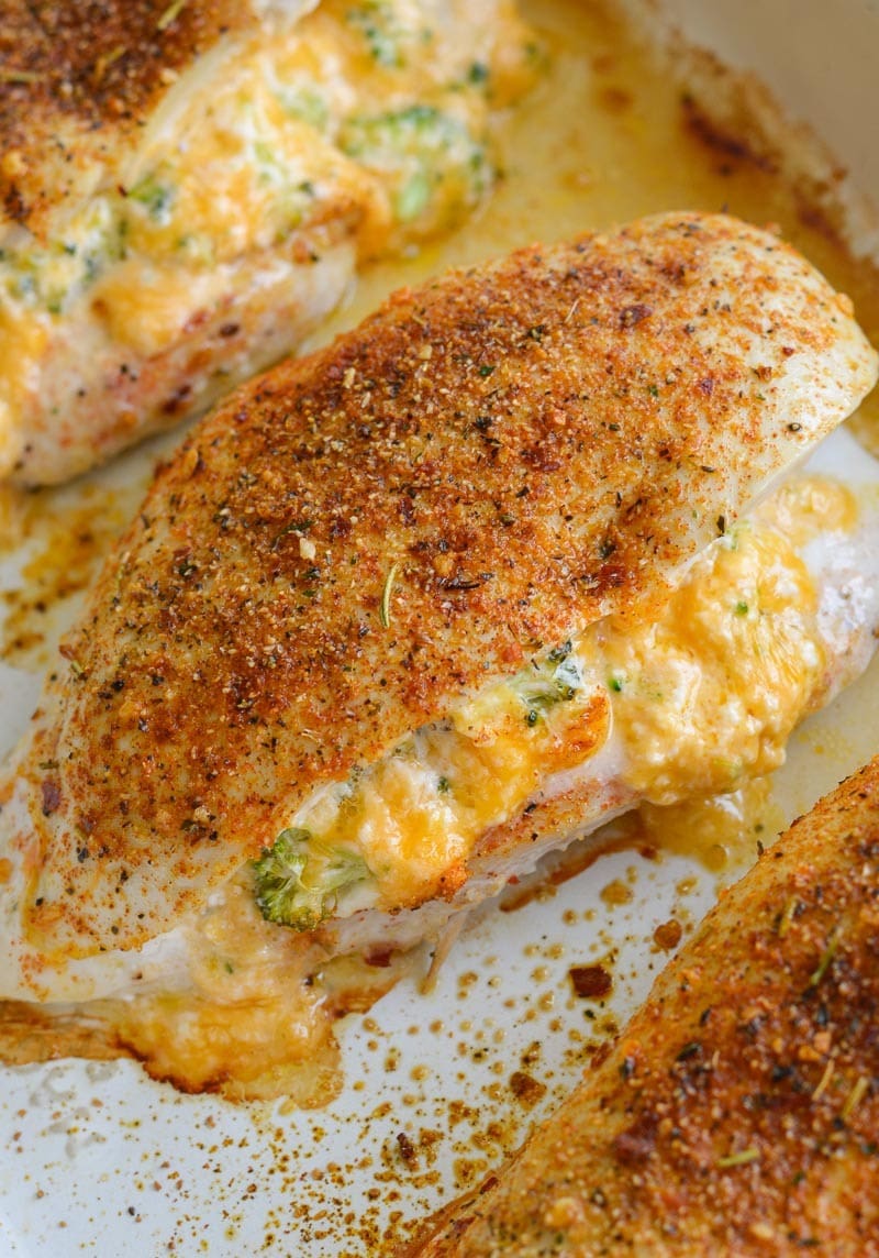Chicken stuffed with cheddar cheese and broccoli on a white dish. 