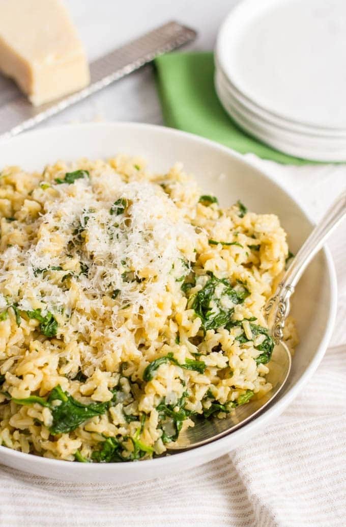Brown rice with spinach and parmesan cheese on a bowl
