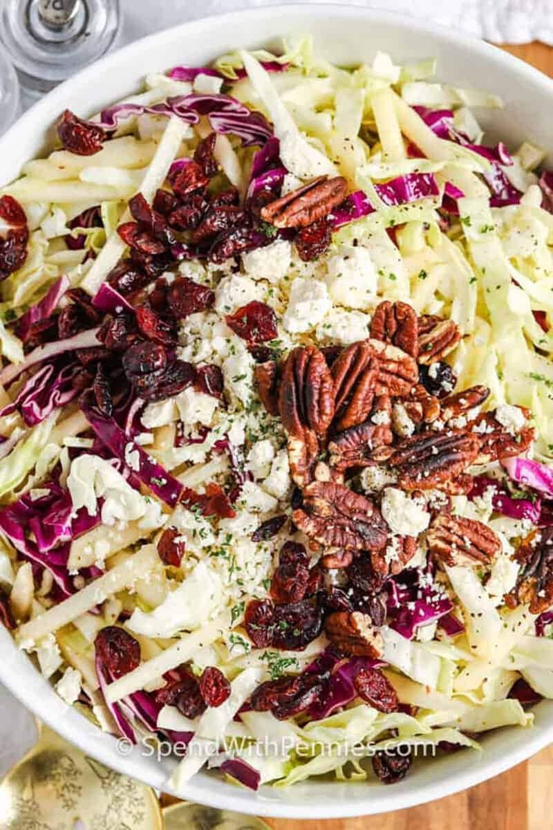 Bowl of cabbage salad with green apples and pecan nuts. 