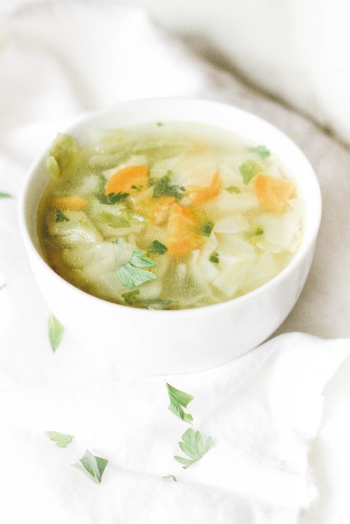 Bowl of Cabbage Soup with Carrots and Parsley