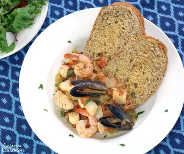 Cacciucco: Tuscan Seafood Stew Served with Bread on a Plate