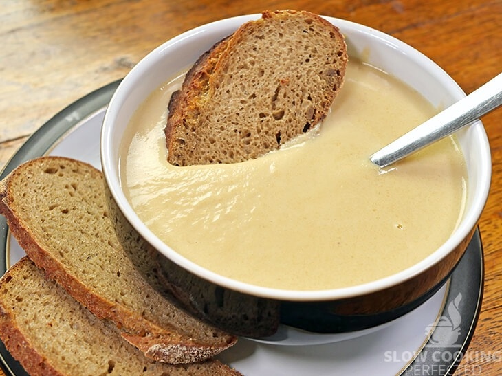 Creamy Cauliflower cheese soup served with sliced bread. 