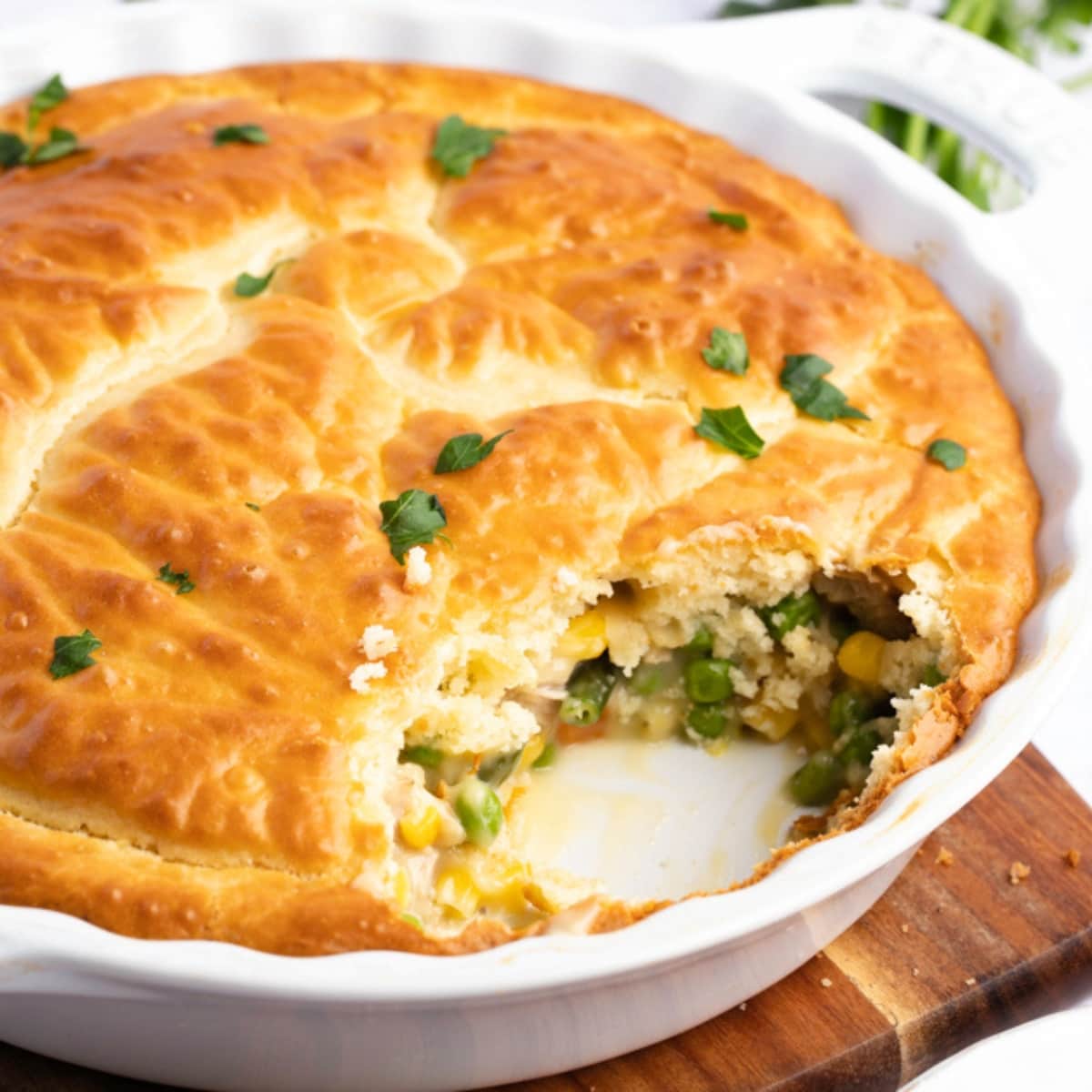 Chicken pot pie on a round dish with peas, chicken meat and corn kernels filling. 