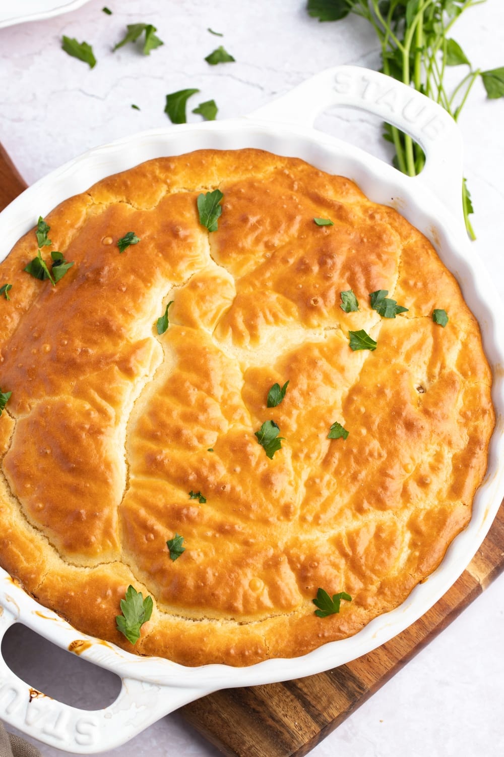 Overhead view of whole chicken pot pie in a round baking dish. 