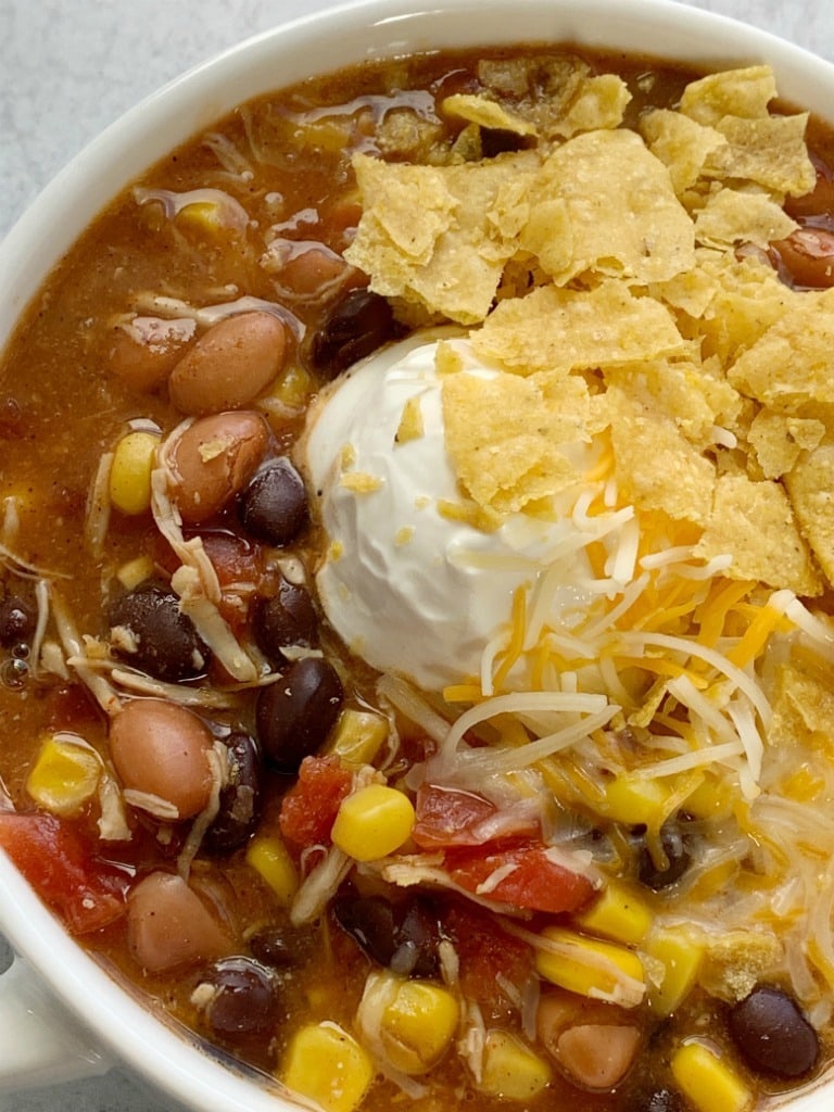 Top view of a bowl of Chicken Taco Soup with beans, corn, diced tomatoes and enchilada sauce