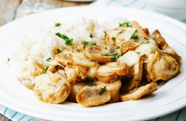 An appetizing combination of chicken, mushrooms, and rice, cooked in a skillet and smothered in a creamy sauce