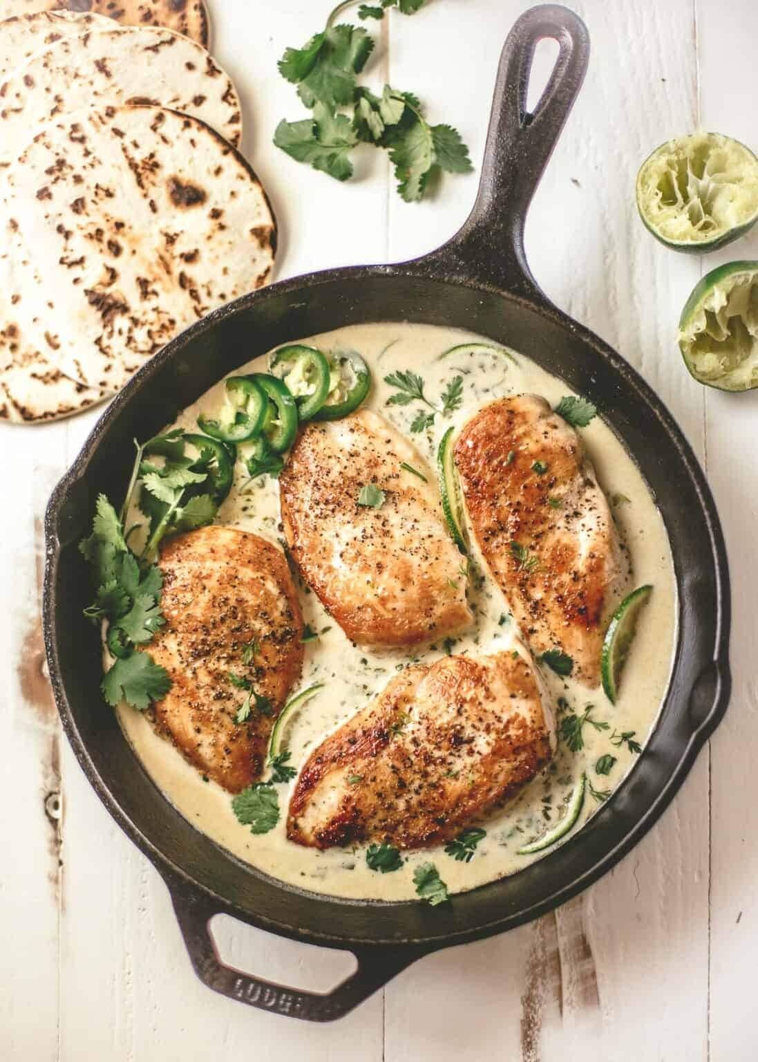 Creamy cilantro lime chicken cooked on an iron cast pan. 