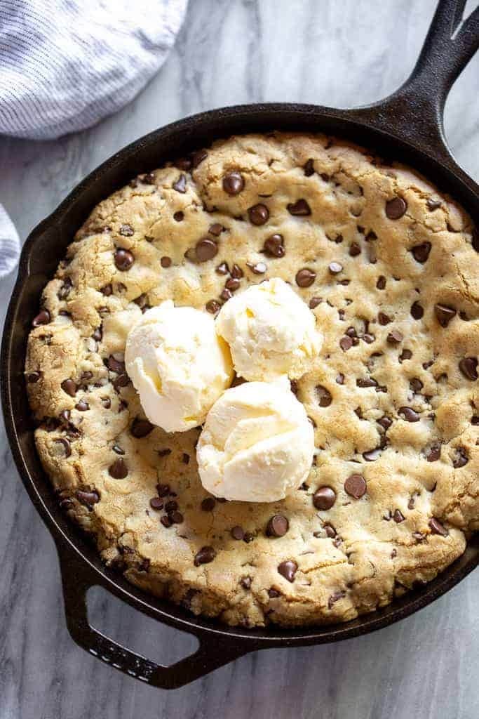 Chocolate Chip Skillet Cookie on a cast iron with ice cream on top