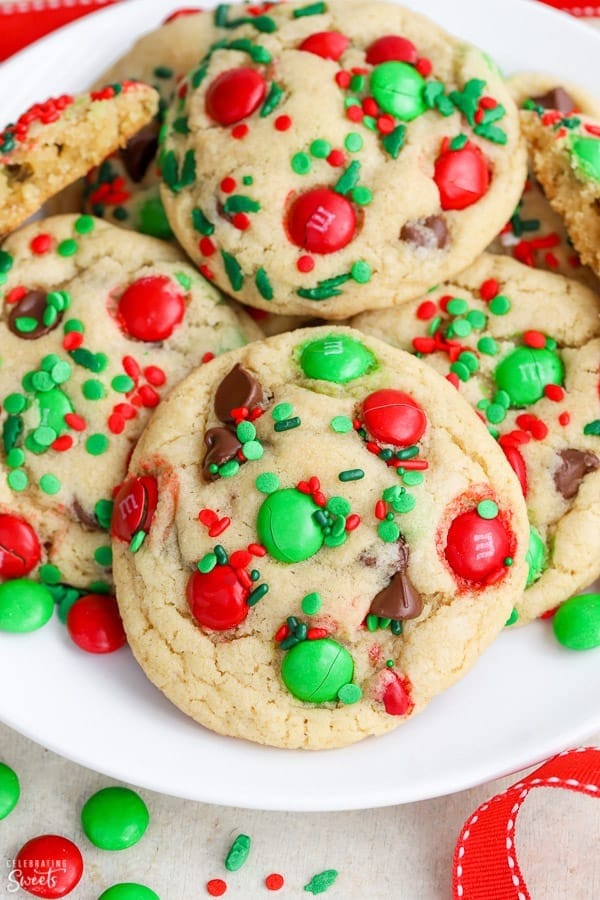 Bunch of cookies with green and red M&Ms and sprinkles served on a plate. 