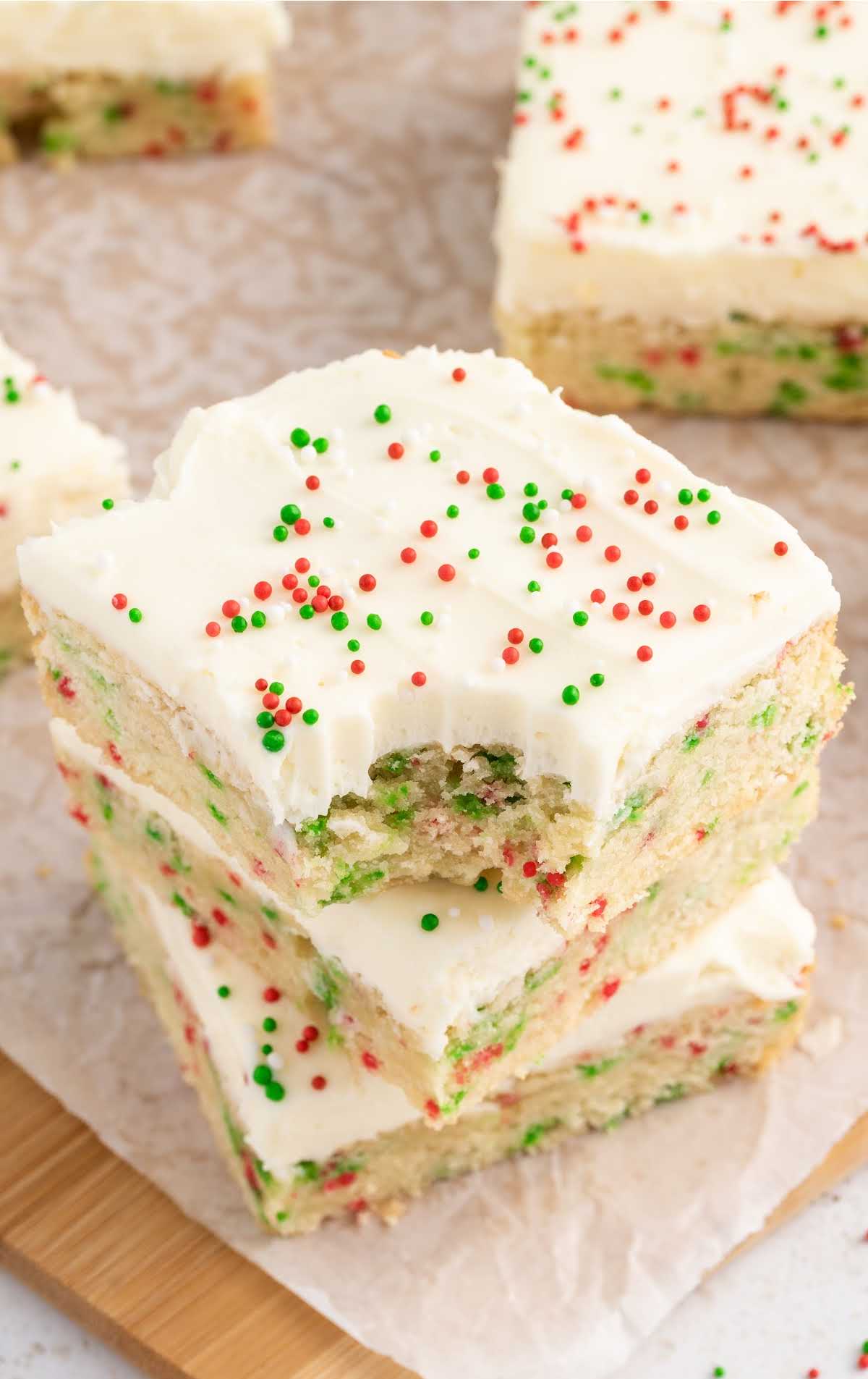 A stack of white frosted Christmas bars on a cutting board