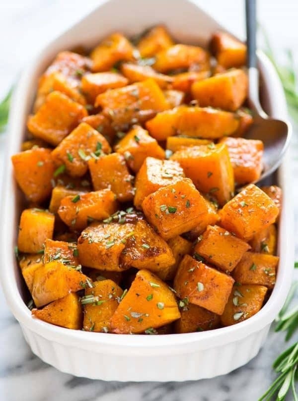 Roasted butternut squash on a white dish with spoon. 