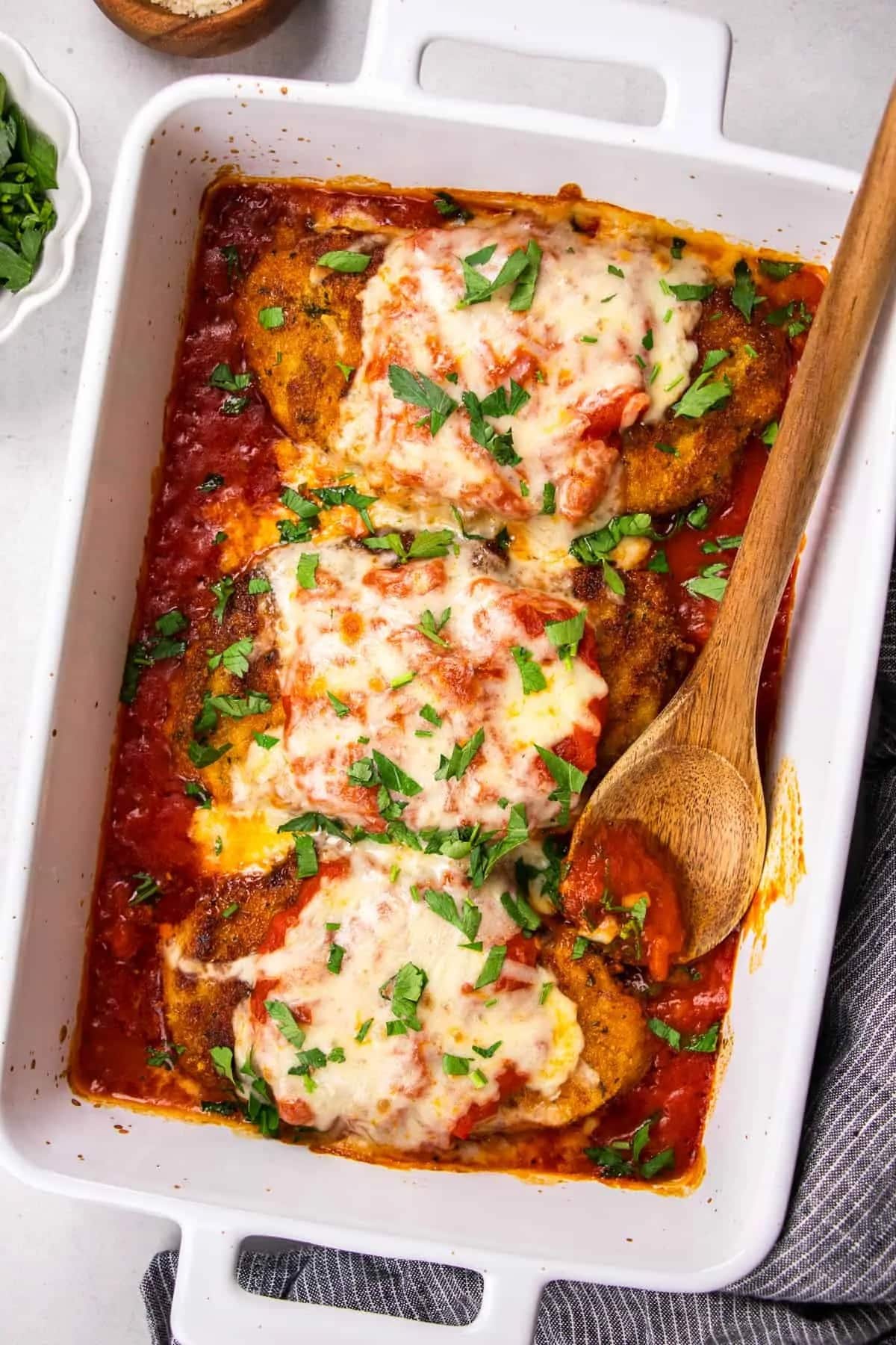 Classic Chicken Parmesan with Parsley in a White Casserole