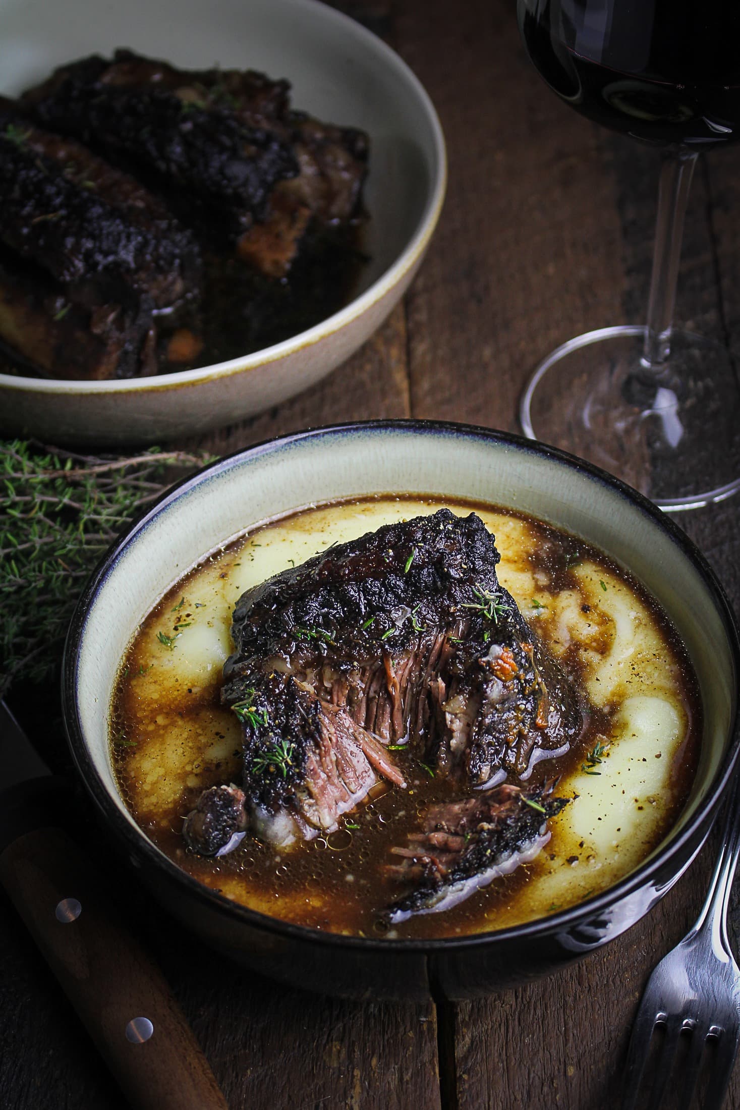 Classic red wine-braised beef short ribs served in a black bowl. 