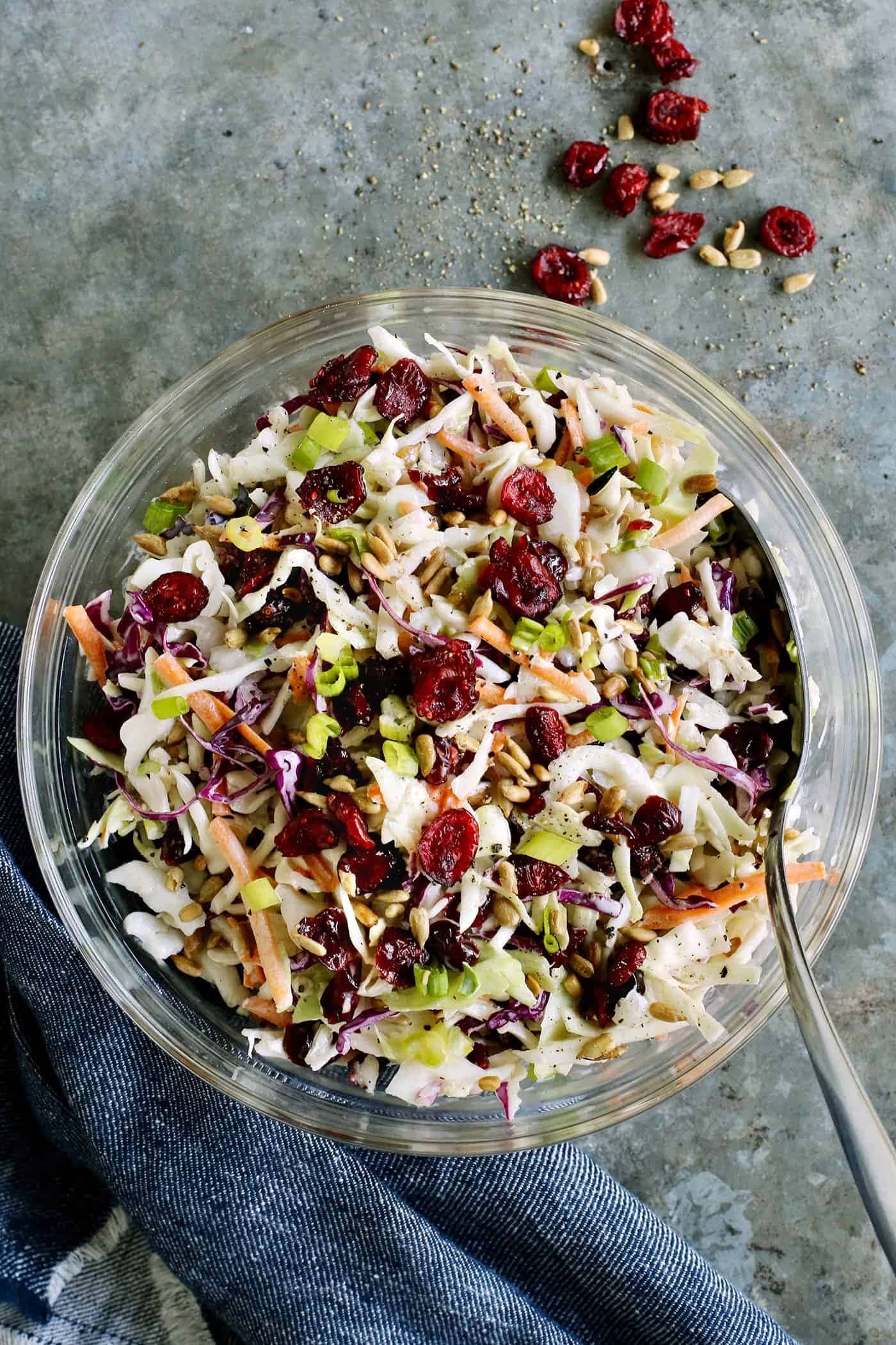 Bowl of homemade Cranberry Coleslaw with shredded cabbage, carrots,  green onions, dried cranberries and sunflower kernels