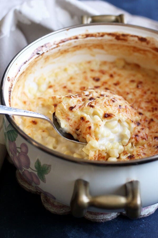Creamed Corn au Gratin in a pot scooped with a spoon