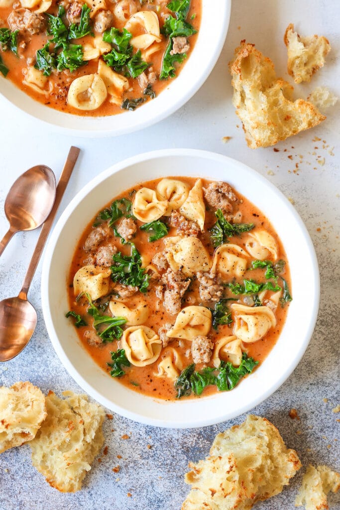 Bowl of Creamy Tortellini Soup with Spinach Served with Bread