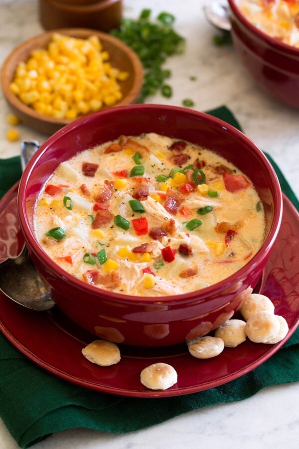 Bowl of creamy chicken corn chowder in a red bowl. 