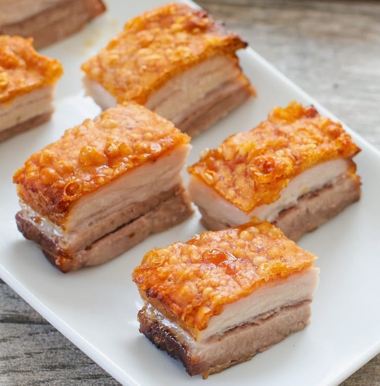  Crispy Golden Pork Belly cutlets on a ceramic dish