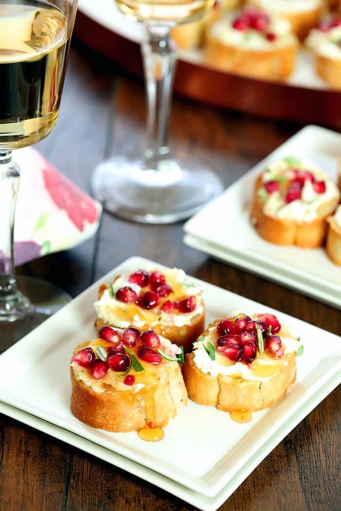 Crostini appetizer with goat cheese and pomegranate arils on top. 