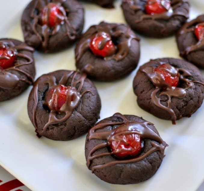 Chocolate cookies with cherries in the middle drizzled with chocolate. 