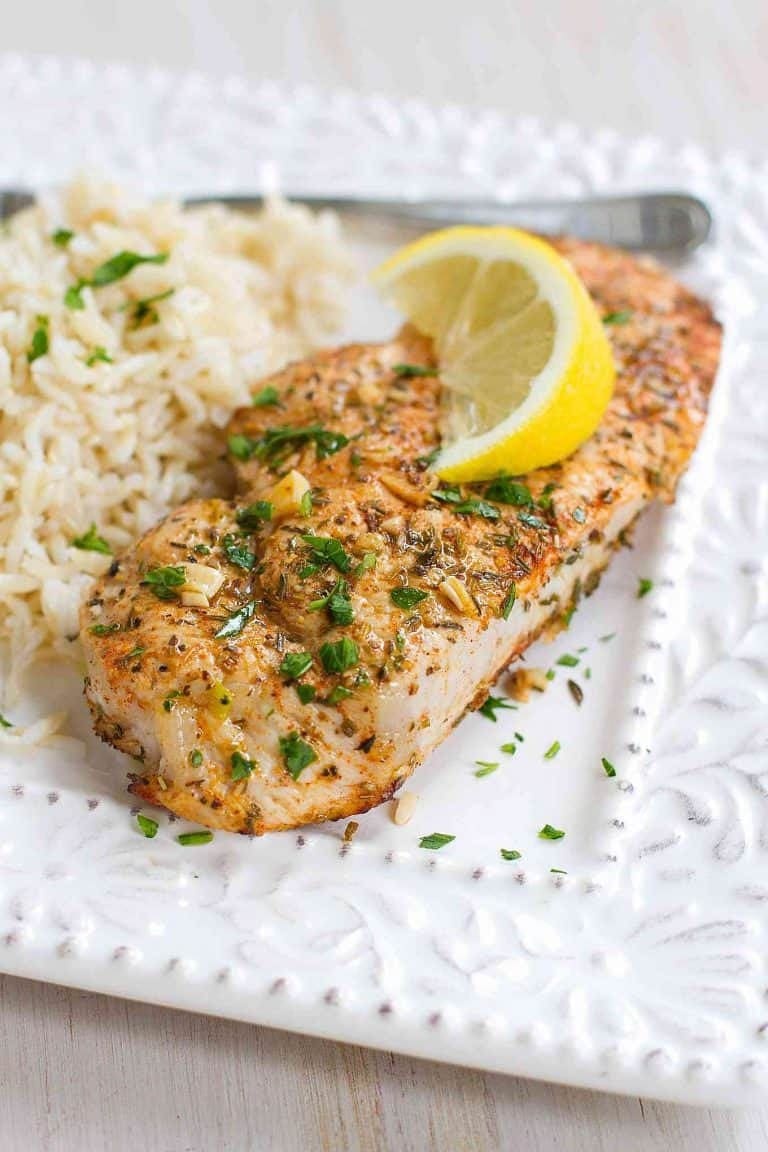 Pork chop baked with lemon and herbs served with rice. 