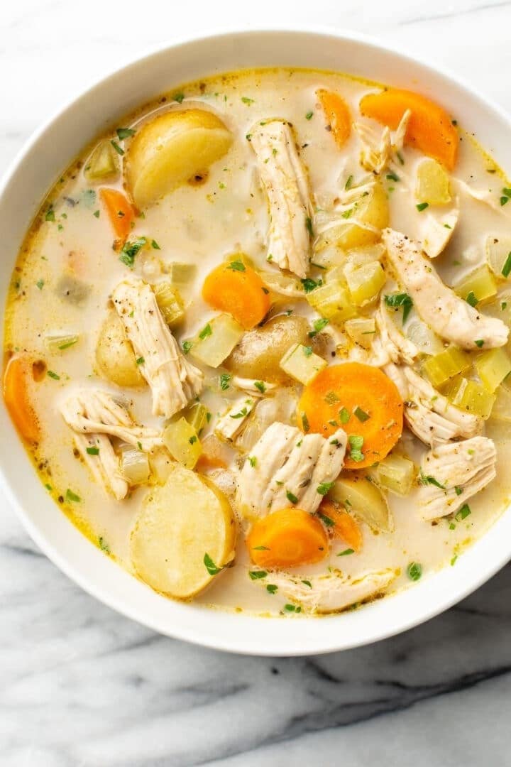 Leftover roast turkey soup on a bowl with sliced carrots and celeries. 