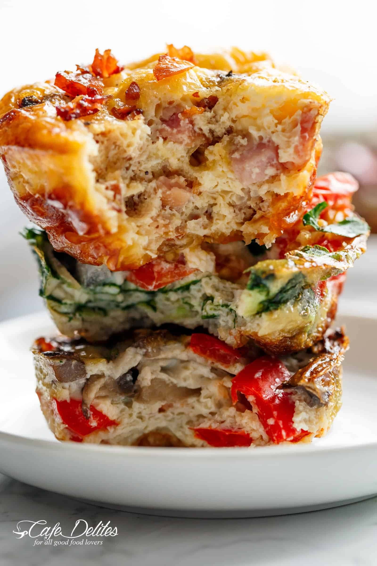 Bitten egg muffins stack on a white serving plate. 