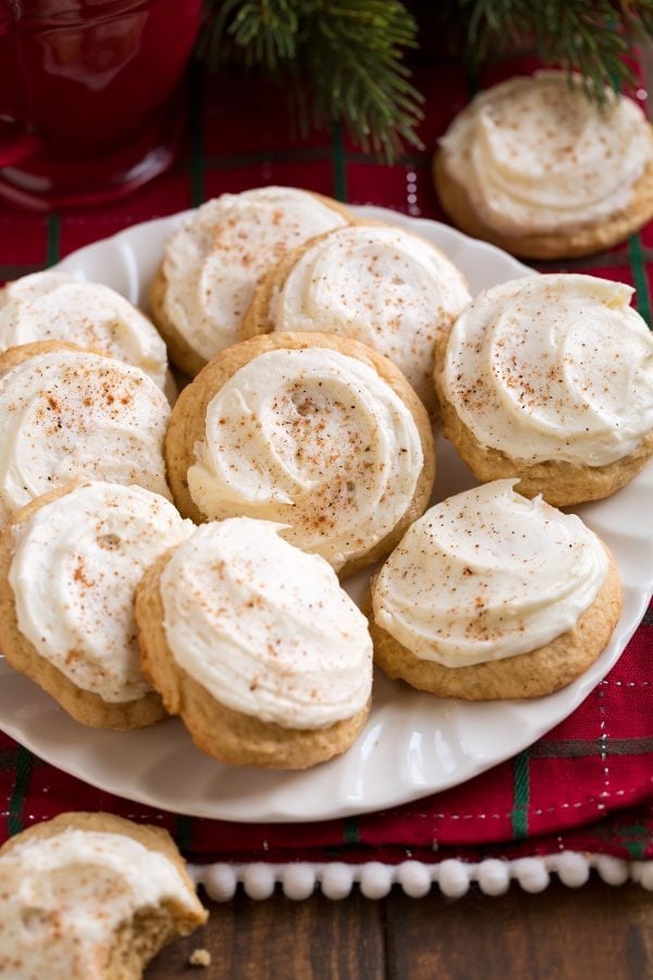 Bunch of eggnog cookies with frosting and sprinkled with cinnamon powder served on a plate. 