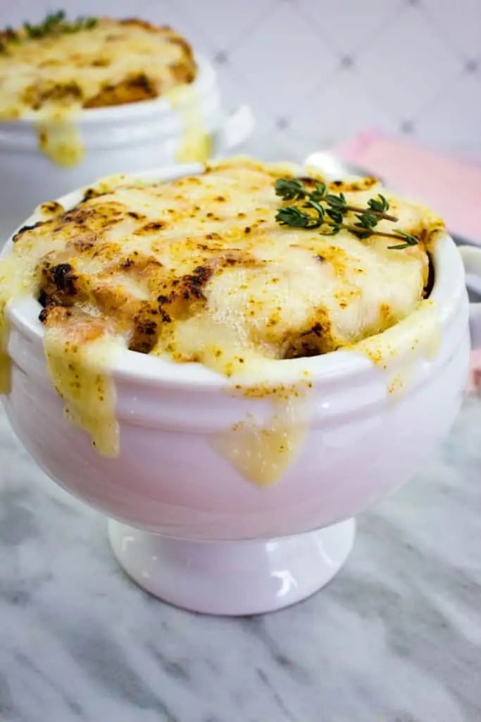 Keto French Onion Soup Garnished with Cheese and Herbs