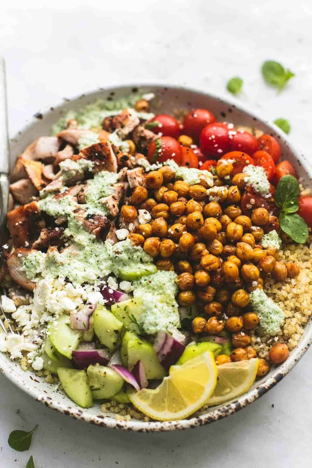 Greek Chicken Power Bowls with quinoa, feta cheese, chicken breast, tomatoes,  green peas and oregano
