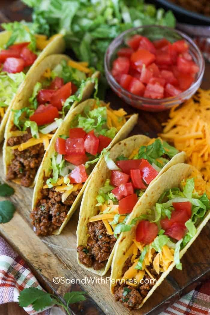 Ground beef tacos with chopped tomatoes, cheese and lettuce. 
