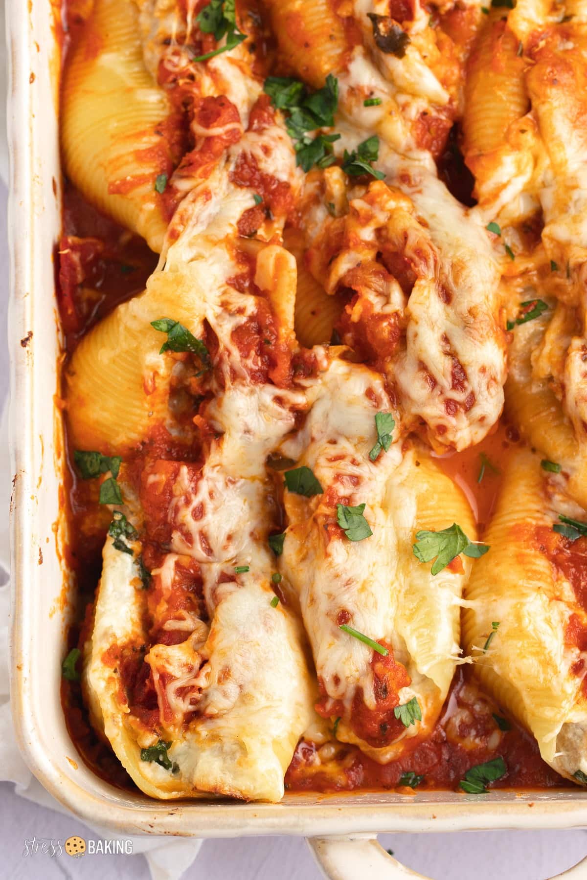 Baked stuffed shells with gooey cheese and savory tomato sauce on a casserole dish,
