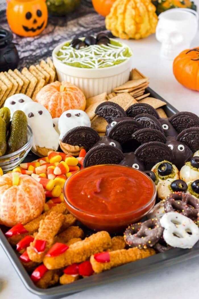 Halloween inspired charcuterie pan with pretzels, pickles, candy corn, and more. 