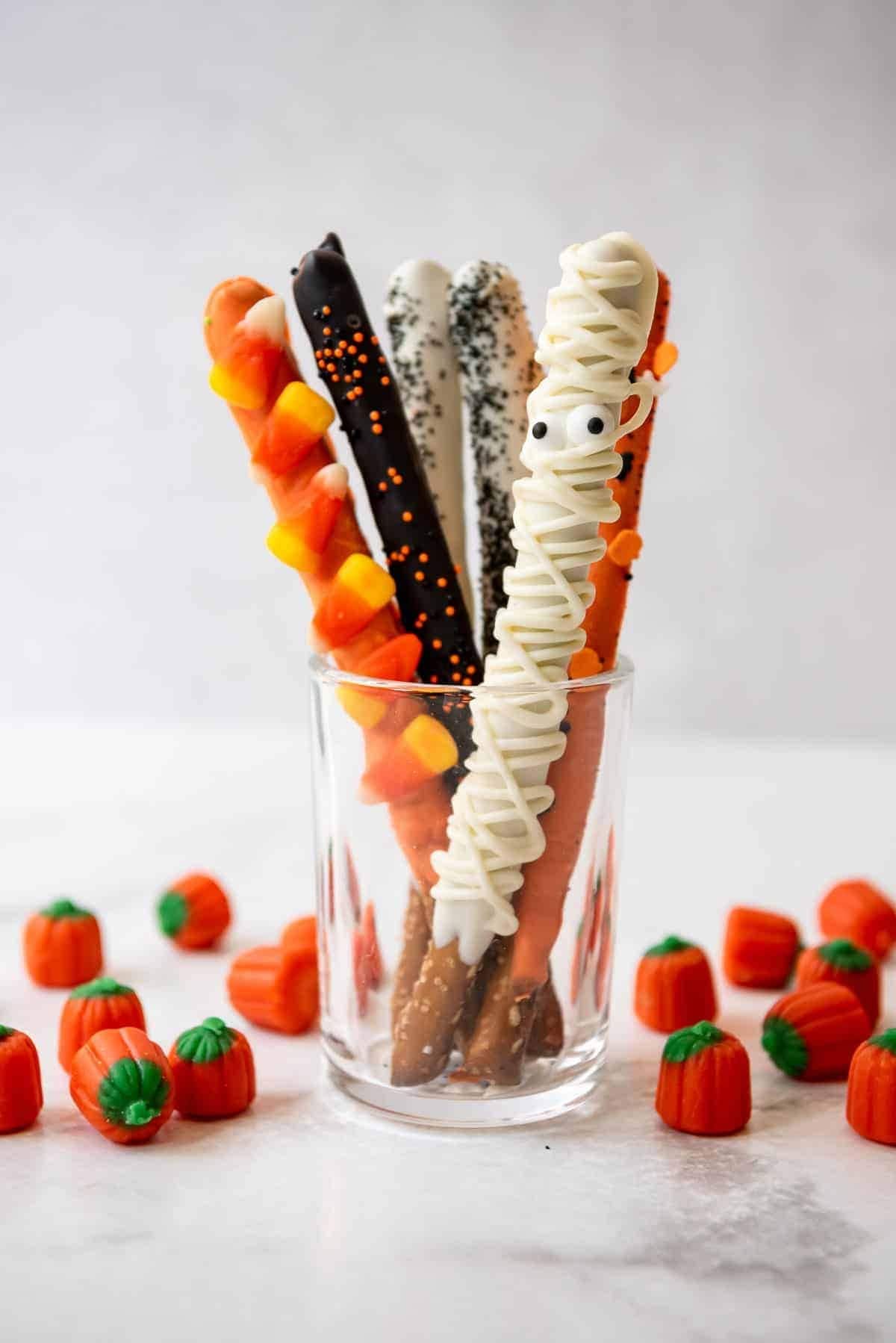 Chocolate covered pretzels designed as Halloween candies in a glass. 