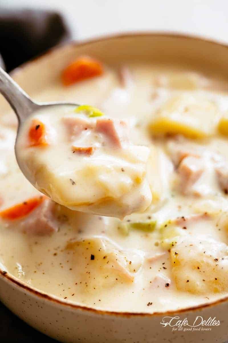 Creamy ham and potato soup in a bowl scooped with a spoon. 