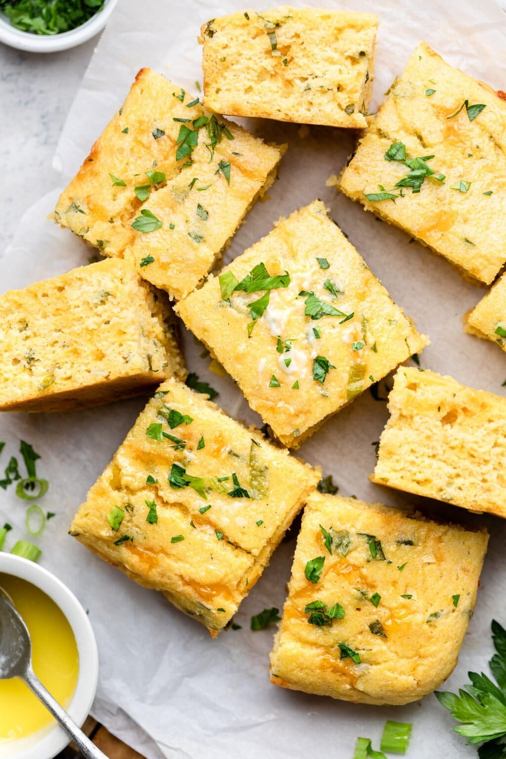 Herbed Brown Butter and Cheese Cornbread squares on a parchment paper